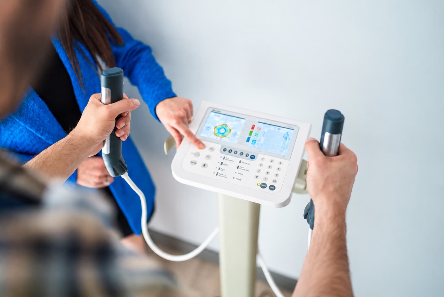 A clinician guiding a patient through a body composition assessment